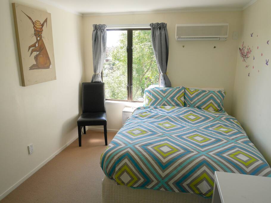 Bedroom includes comfy double bed with dual control heating blanket, desk with mirror hanging above, additional full length mirror, nice view with lots of sun, air conditioning/heatpump, and lots of closet space.