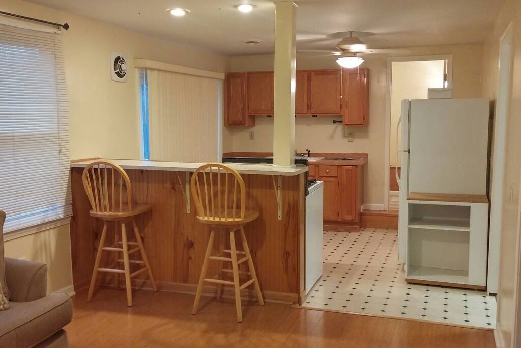 Bar seating area adjacent to cooking area with independent overhead lighting.