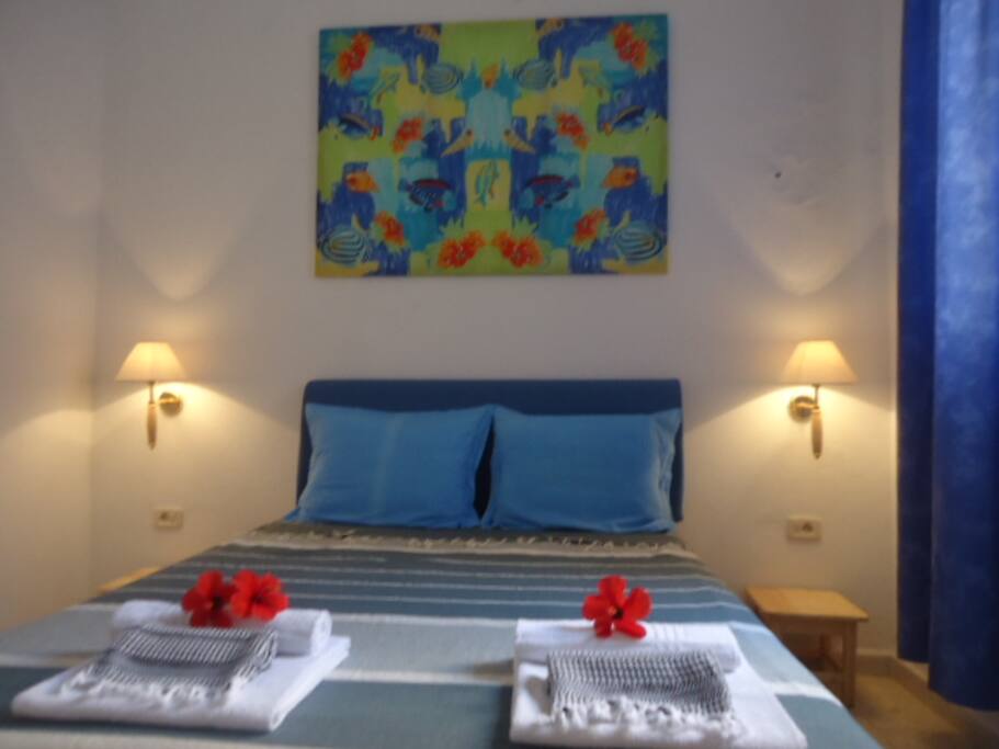 Chambre Azur
L'Azur transporte, c'est comme un voyage tranquille et doux dans un barque au fil d'une rivière. Couleur qui berce, couleur lente et tranquillisante. Symbole de vie et de déplacement lent, la couleur azur invite au changement progressif, à la concentration. Permet de fixer les idées, invite à la concentration, et à la paix de l'esprit. Couleur qui ralenti les processus, qui soulage les personnes agitées avec douceur et tact. L'azur rappelle les eaux peut profondes, les lignes d'eau, la fraîcheur d'un matin. Couleur qui hydrate et qui donne confiance, et offre une sensation de sécurité.