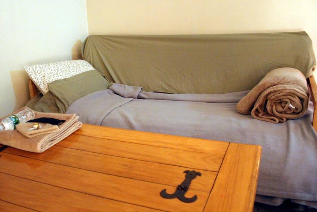 Living room futon-couch made up for a guest
