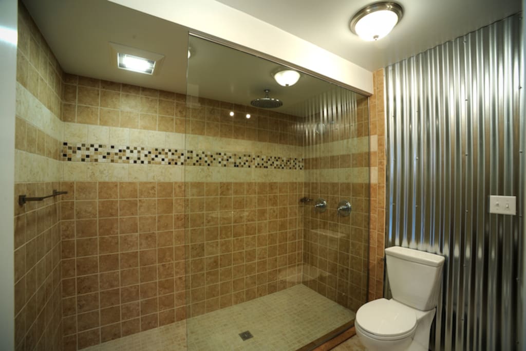 This shower fits 8 people easily. There is a 12" rain head and a normal shower head that will run simultaneously.