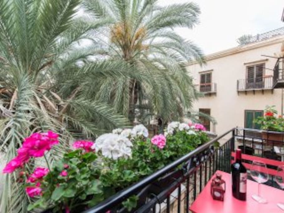 The sunny balcony overlooking a palm trees courtyard
