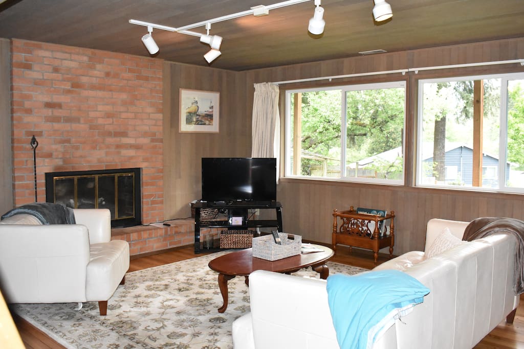 Living Room with brick fireplace, TV, WiFi and breathtaking view of a private back yard.