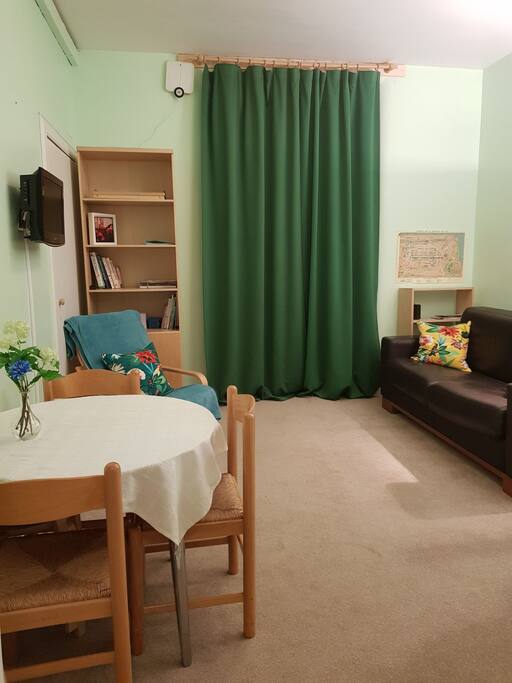 This is the living room with sofa made up. Please let us know how many people are staying ahead of your visit and we'll have the beds set up for you. Living room arm chair nook - there are a few kids' books and toys on the bottom shelf for your kids to enjoy while you're there. Please tidy up after use.