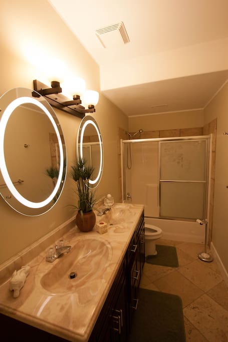 Bathroom with double sink, shower and bath tub.