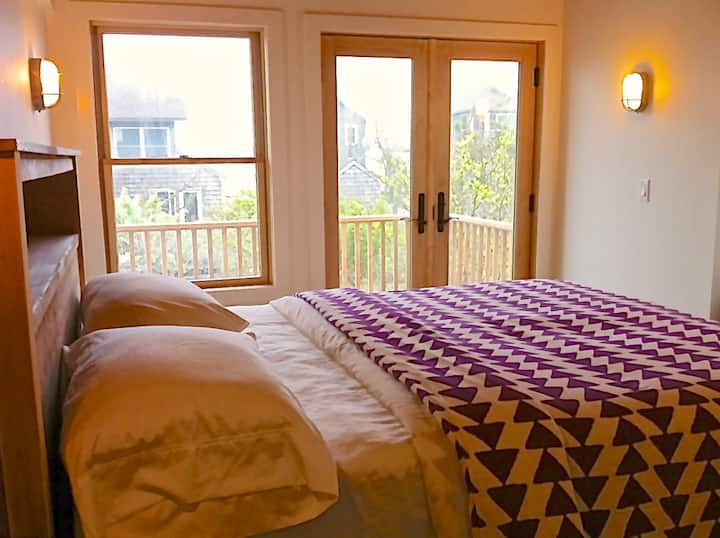 חדר שינה ראשי שני עם מרפסת פרטית ונוף לים.  שולחן עבודה מרחוק.