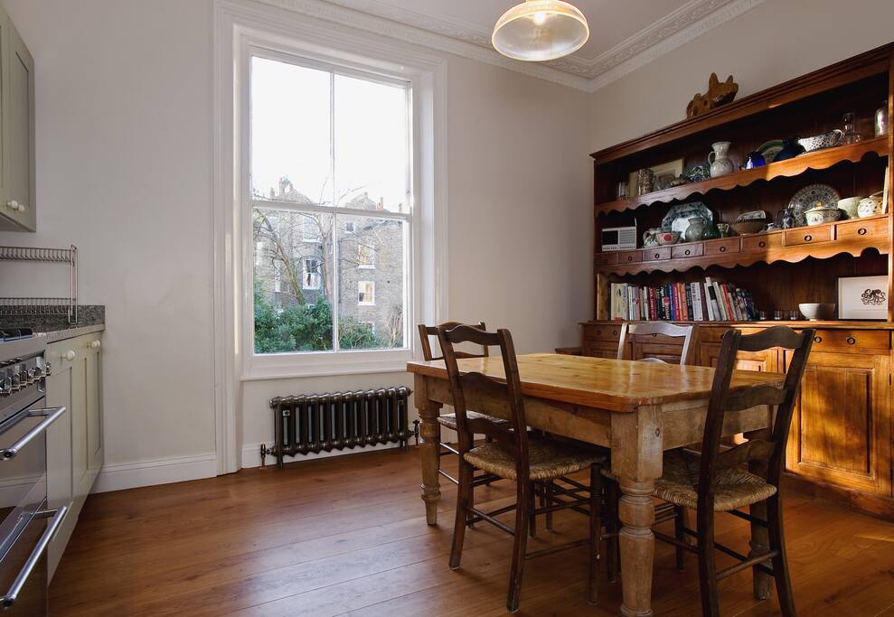 Dining table in the kitchen with a large south facing window overlooking the garden