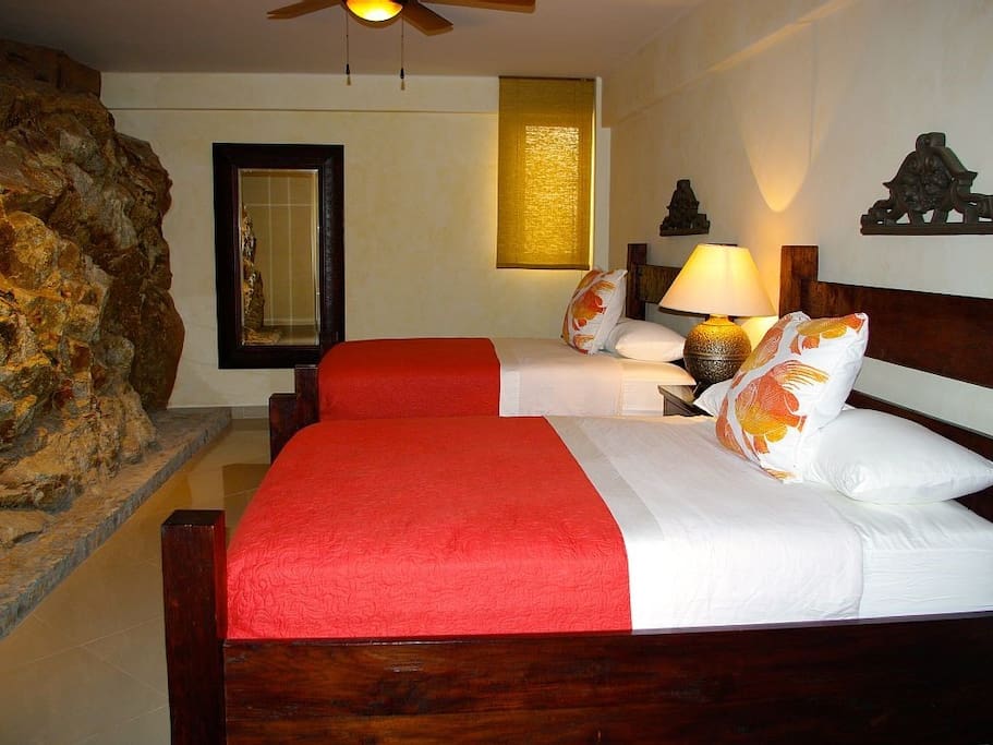 Slaapkamer met natuurlijke rotswand.