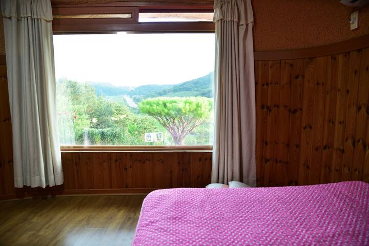 뷰가 아름다운 침실
16년에 주인장이 직접설계해서 직접 지은 황토방으로 산 언덕에 위치해서 다양하게 창밖 풍경을 감상하실수가 있는 객실 입니다