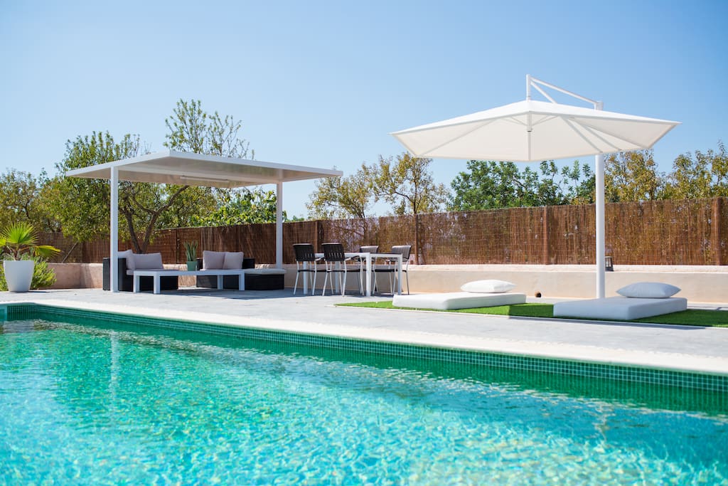 Pool with sun beds, comfortable day beds with shade, sofa corner and table and chairs