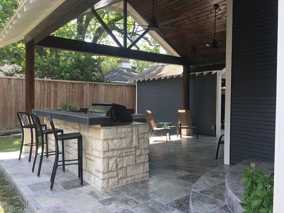 Outdoor kitchen entertainment area with custom cabinets, gas grill, dual gas burners, ice maker and fridge.