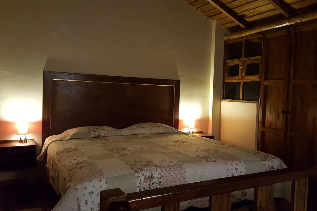Habitación. Cuenta con una cama de tres plazas (king size) y acceso al balcon. Los materiales usados en la construcción hacen q sra fresca de dia y calida en la noche