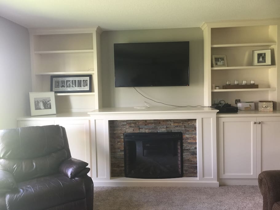 Downstairs living room, featuring entertainment center and fireplace