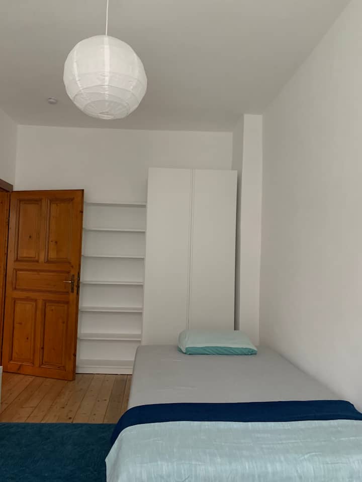 Habitación 1: "Habitación al patio" (sol de la mañana) con cama de alta calidad (1,20 x 2,00 m), armario y estante. La habitación es muy agradable, especialmente en verano cálido.