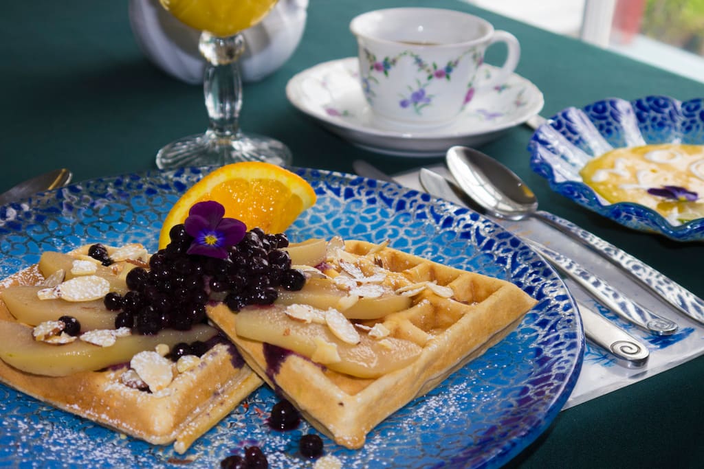 Waffles with gingered pears toasted almond wild organic blueberry compote served with organic Maine maple syrup. Chilled mango and lime soup juice and coffee all part of your breakfast at Acadia's Oceanside Meadows Inn.