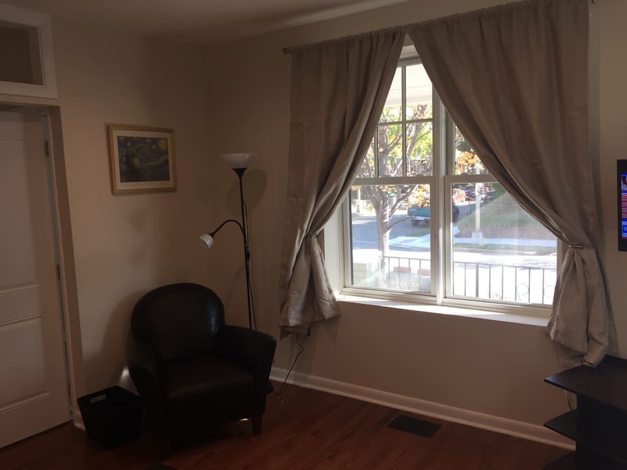 Living Room features large window for light and armchair reading and relaxation.
