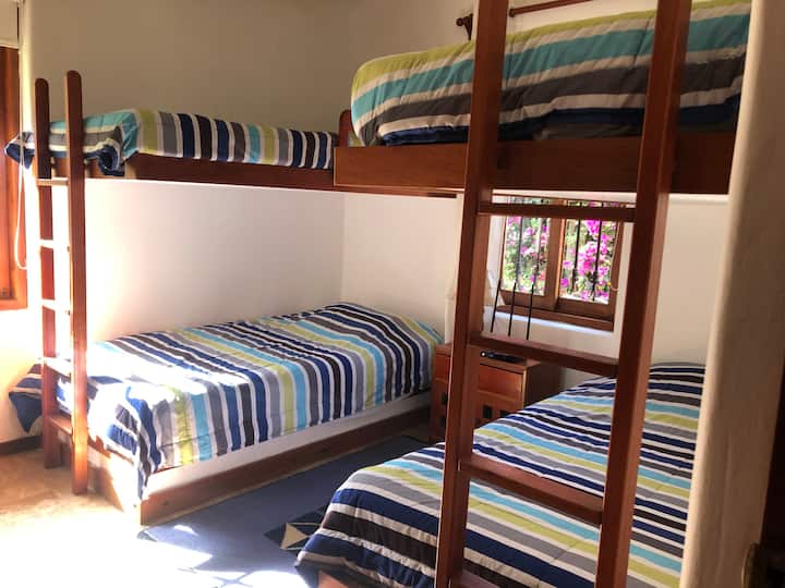 Chambre avec deux lits superposés carrés et demi avec garde-corps de protection.