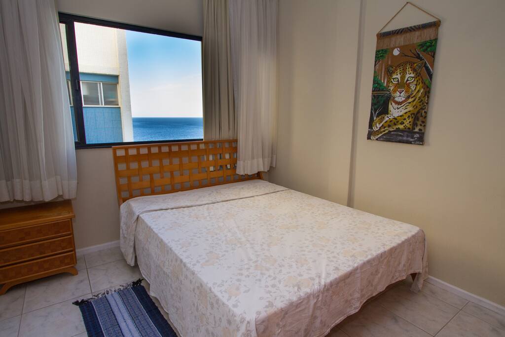 Quarto com cama de casal e vista mar