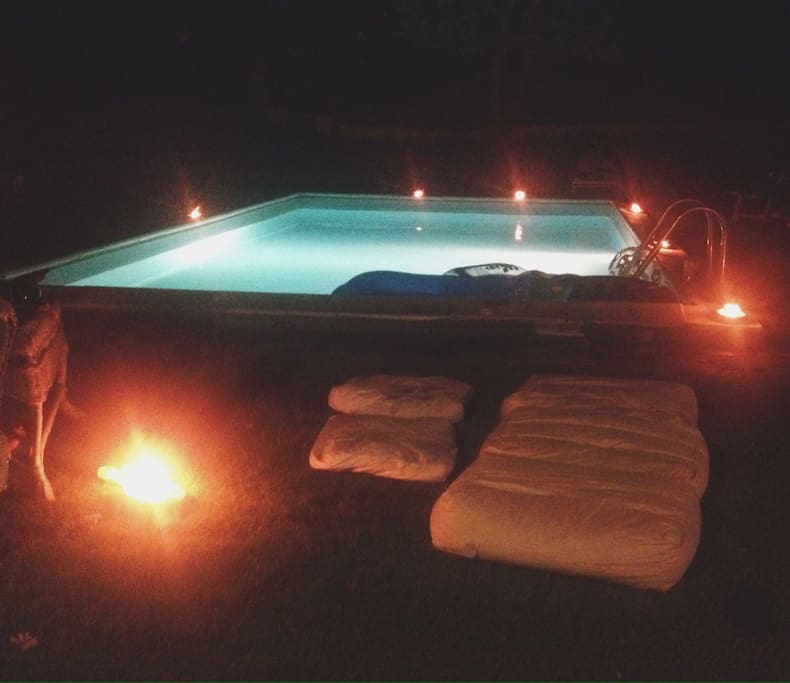 Swimming pool at night with candles on the side