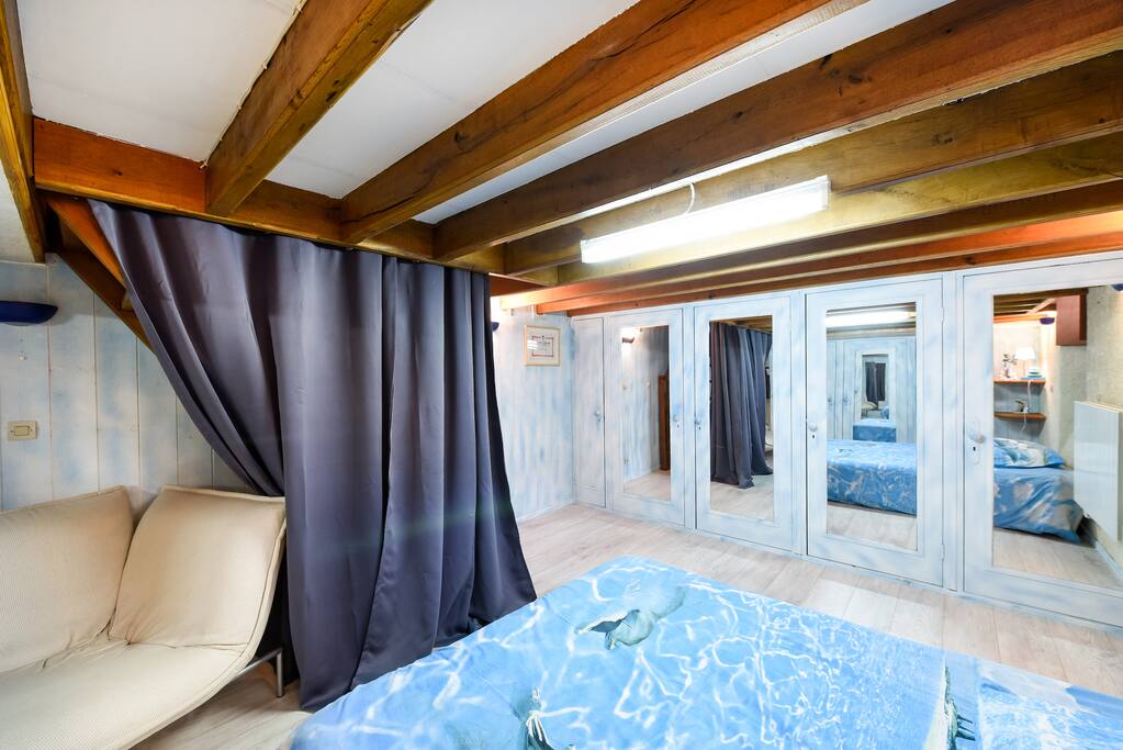 Chambre spacieuse, dans sous-sol. Rideaux. Hauteur : 1,85 cm