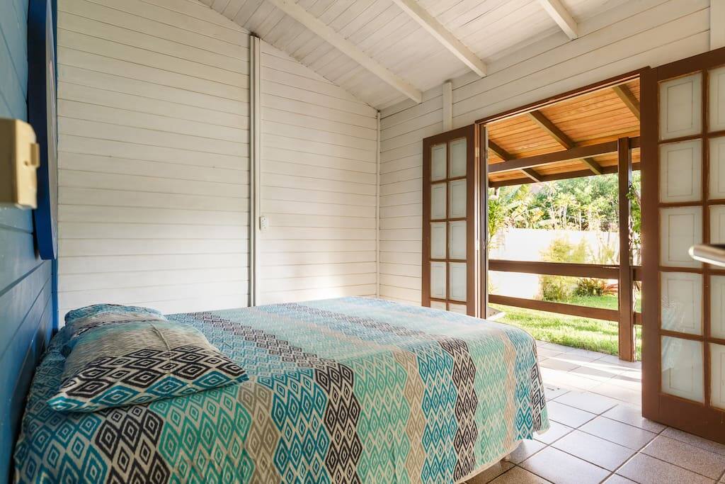 Quarto de casal I com ventilador de teto bem arejado e vista para o jardim.