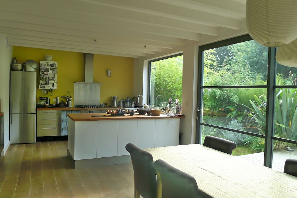 La cuisine ouverte sur la salle de séjour, le salon et le jardin.