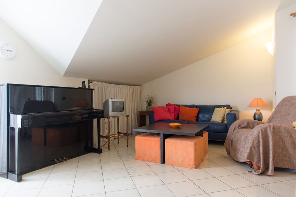 Salotto: pianoforte, tavolo bambini, tv via cavo, divano letto, poltrona massaggi