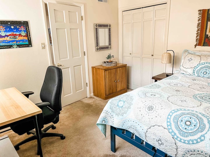 Una cama de tamaño completo y un lugar cómodo para trabajar.