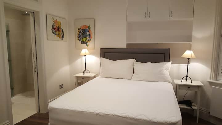 Dormitorio con cama tamaño king y baño privado