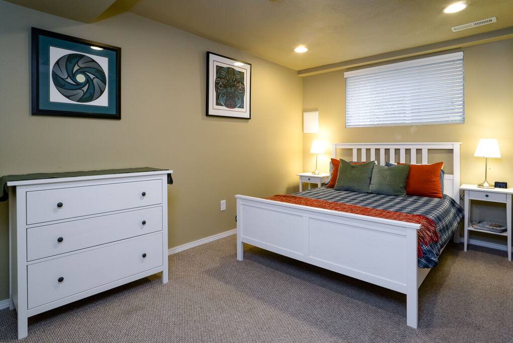 Larger bedroom with queen-sized bed and dresser.