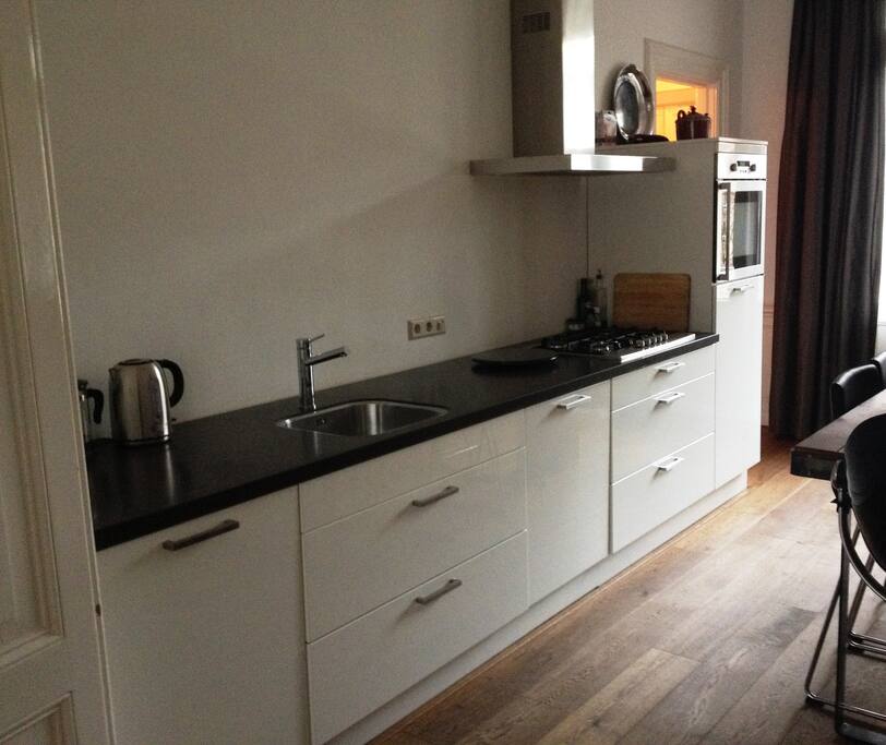 A modern kitchen including all appliances; fridge, freezer, fan-oven, dishwasher, microwave and 5 hobs cooker.
