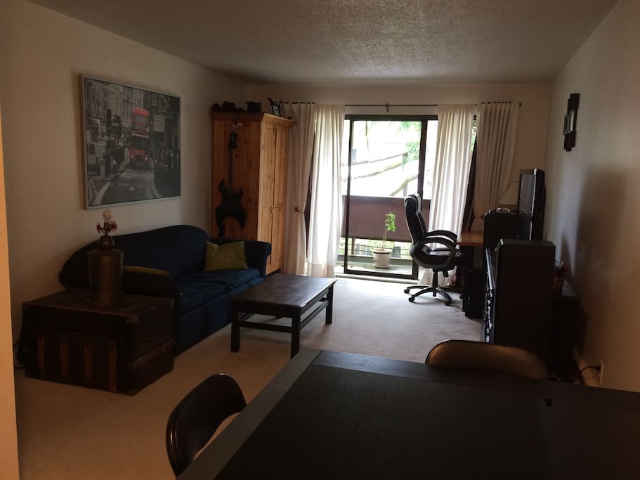 Living room and access to the balcony, 1 desk and 1 TV.