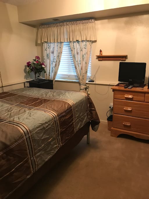 Guest room with full bed, dresser for storage, tv, microwave, and mini fridge.