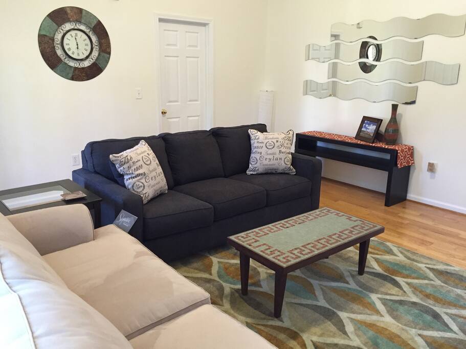 Alternate view of living room with two full-size sofas and door to master suite