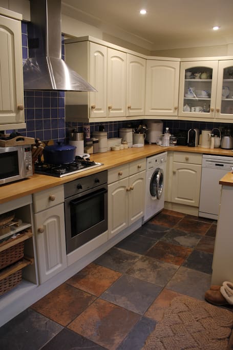A well equipped kitchen with miele dishwasher and washing machine and a large belfast sink.