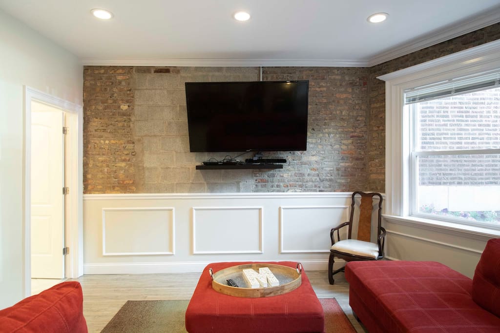 Large screen Smart TV in living room. Access to bathroom in door to the left.