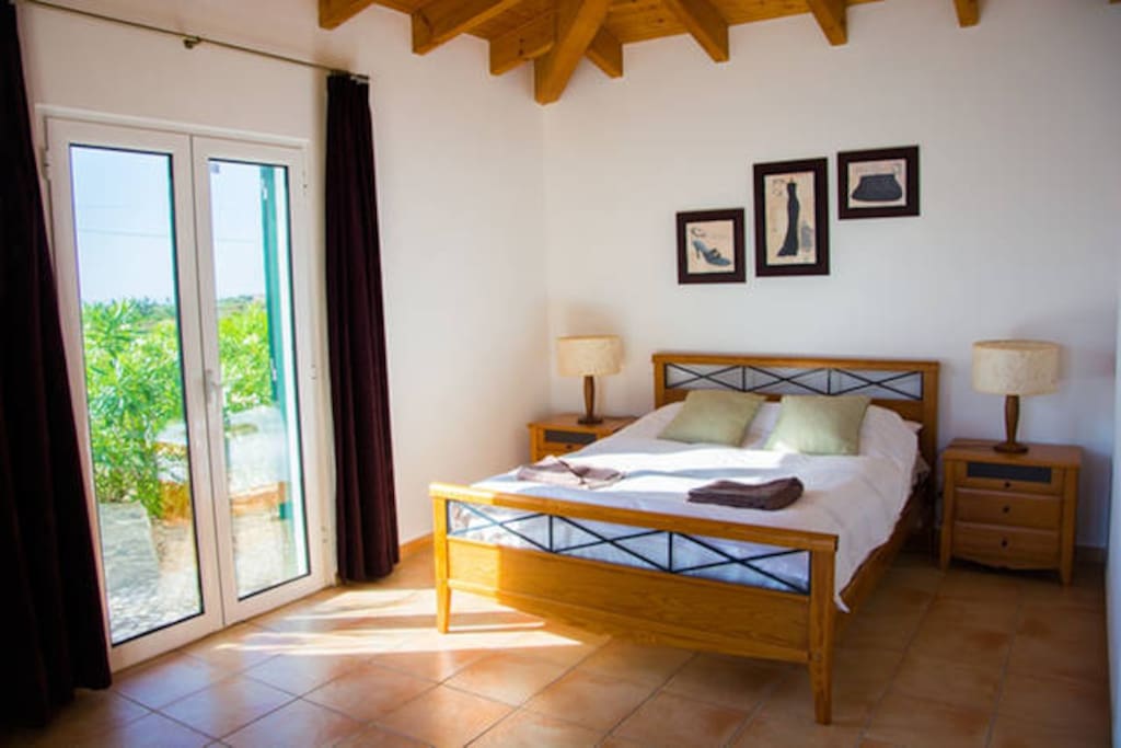 This is our ensuite Bedroom, Spacious and has a view of the garden and pool.