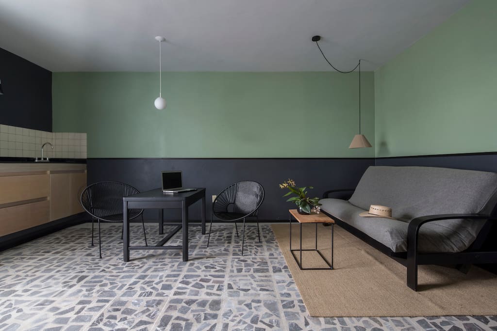 Cómoda área de estar con sofá cama individual y cocina.