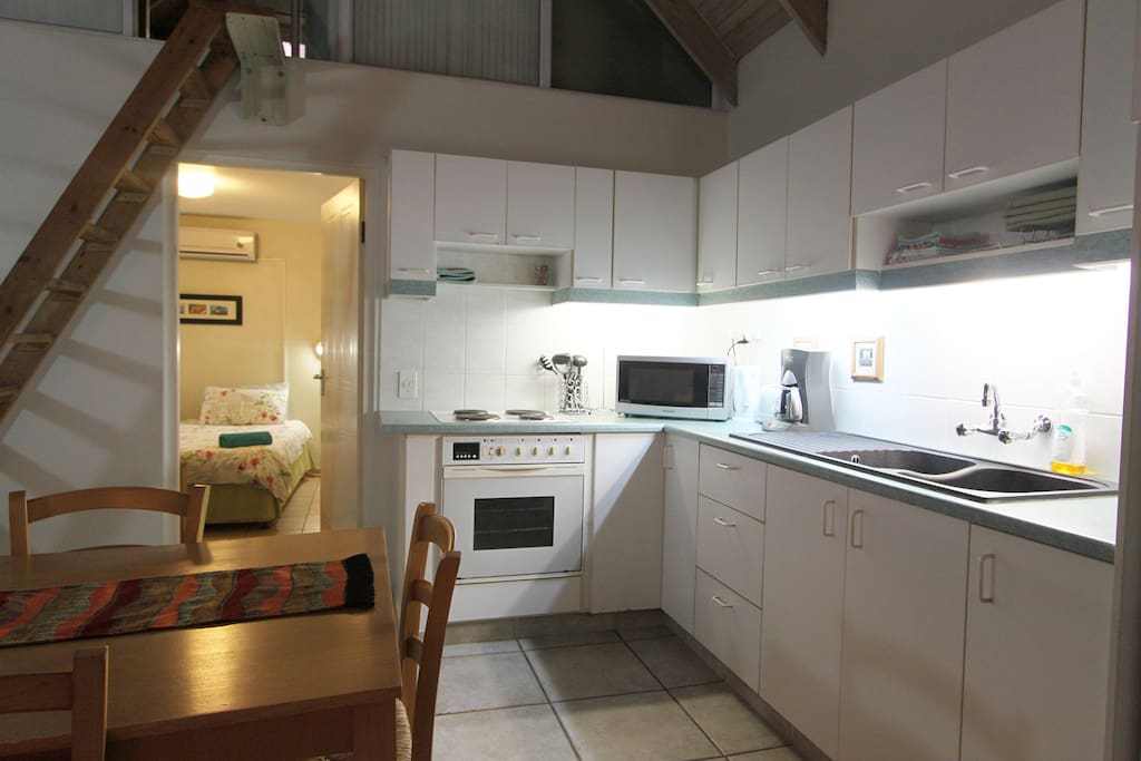 Kitchen area with a sneak peek into the main bedroom's doorway.
