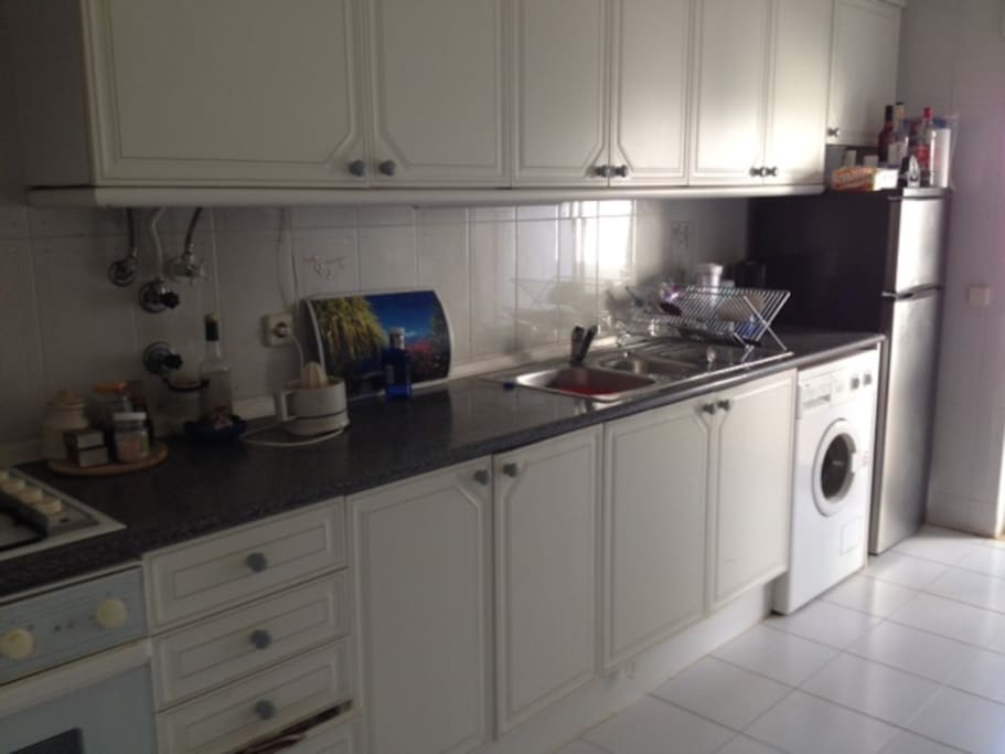 Fully equipped kitchen with sliding doors leading to a balcony