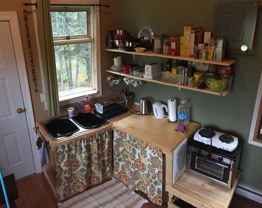 Kitchenette with mini fridge, kettle, hot plate, toaster oven, coffee and tea, and cooking supplies.