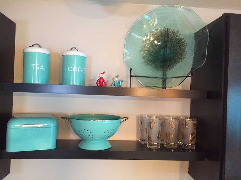 The turquoise adds a vintage flair to the kitchen, the curtains are turquoise and brown.