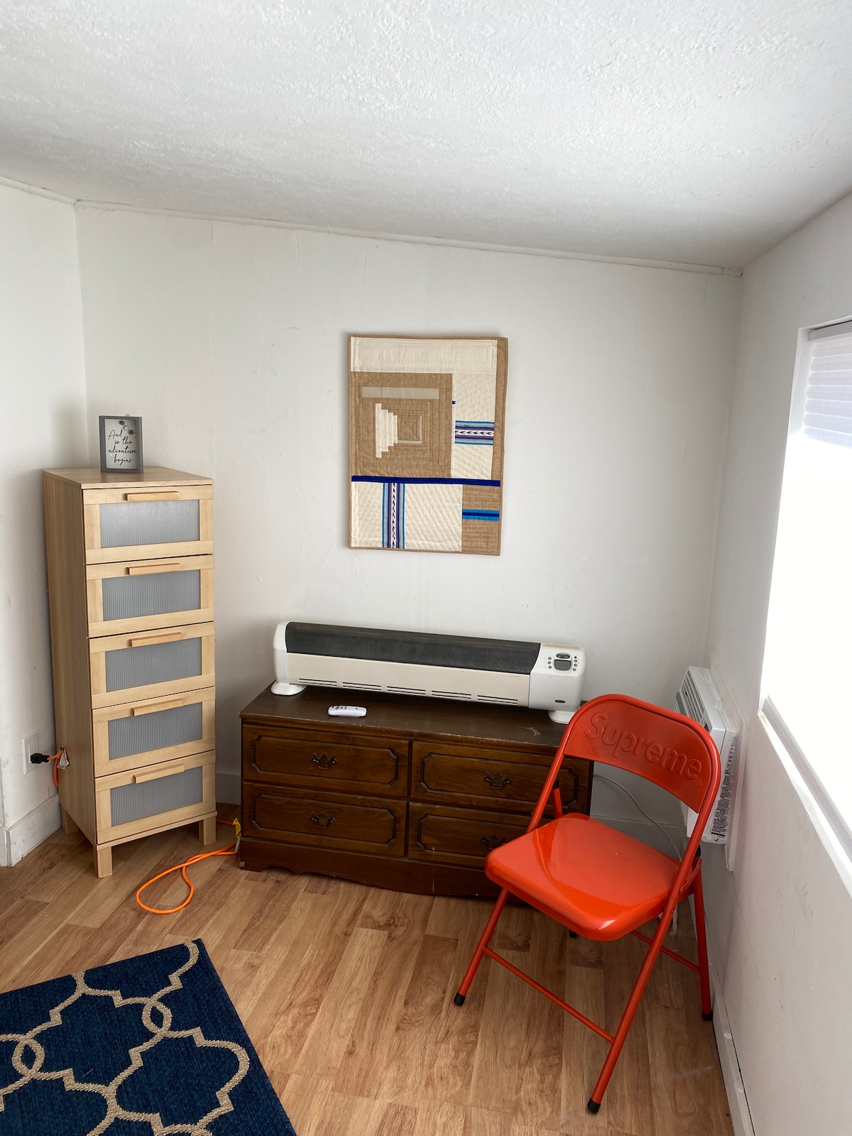 Bedroom number one organizer Ms cheat of drawers. Wall quilt painting is by artist Lavialle Campbell. 