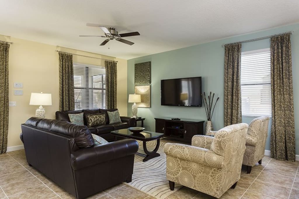 Grand living area with 50-inch plasma TV, Blu-ray player, 1080p HD cable, and direct pool/patio access