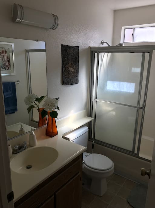 A bathroom all to yourself with shower/bathtub, clean towels, shampoo, body wash, and hair dryer.