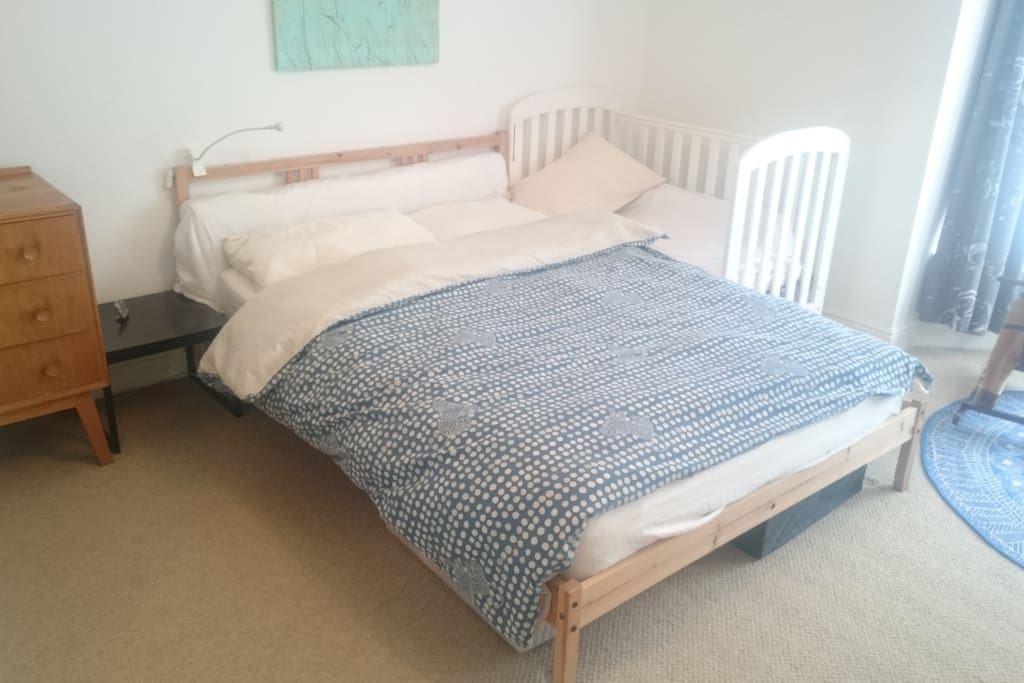1st bedroom with a double bed, a cot, dressing table, wardrobe and a chest of drawers.