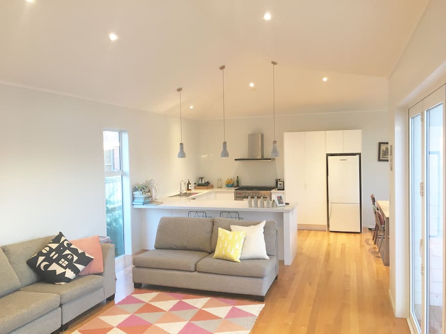 Light, airy open plan lounge, dining and kitchen includes a cosy wood fire and opens to a large deck.