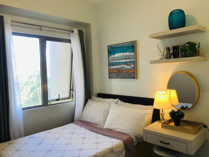 غرفة النوم الأولى. 
ضوء كافٍ ونسيم منعش قادم من النافذة الضخمة يجعل غرفة النوم هذه مكانًا مريحًا جدًا للراحة والاسترخاء. لا حاجة لتشغيل مكيف الهواء في يوم مثل هذا . 