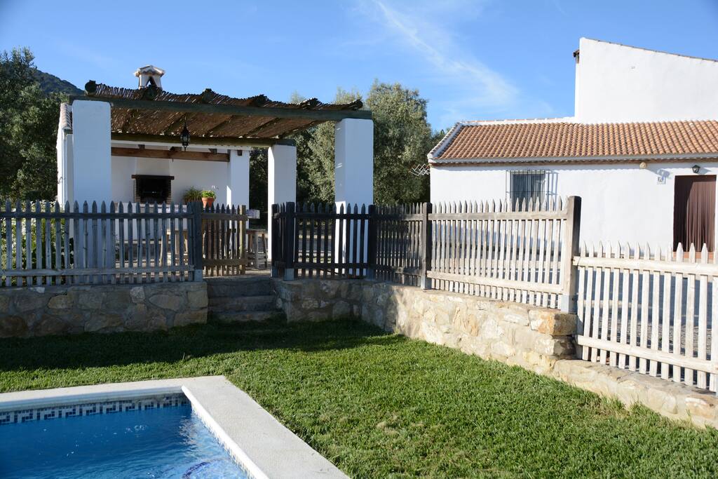 Zona de barbacoa entre la piscina y la casa