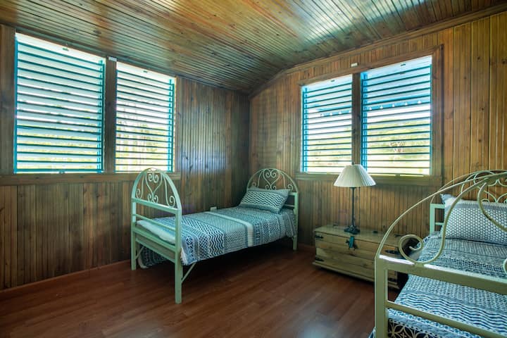 Habitación con dos camas individuales junto un hermoso panorama en madera